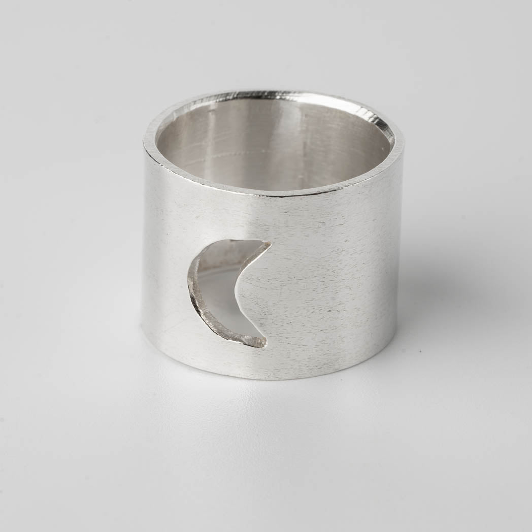 Bred silverring i Àkta silver med en utskuren mÄnskÀra, handgjord och elegant, fotograferad mot vit bakgrund.