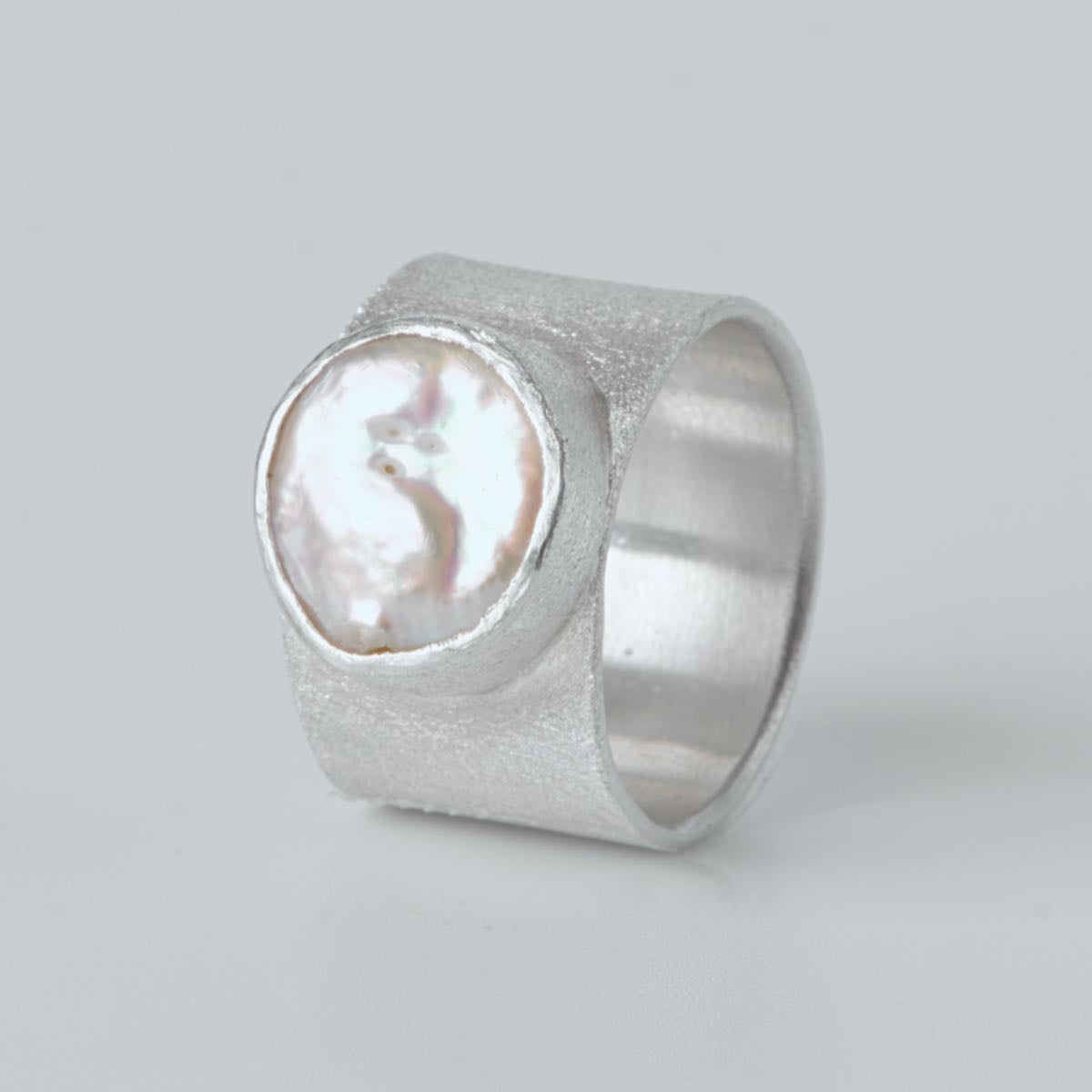 Modellen Pärla från Nude Stockholm – bred silverring med pärla, handgjord i äkta silver