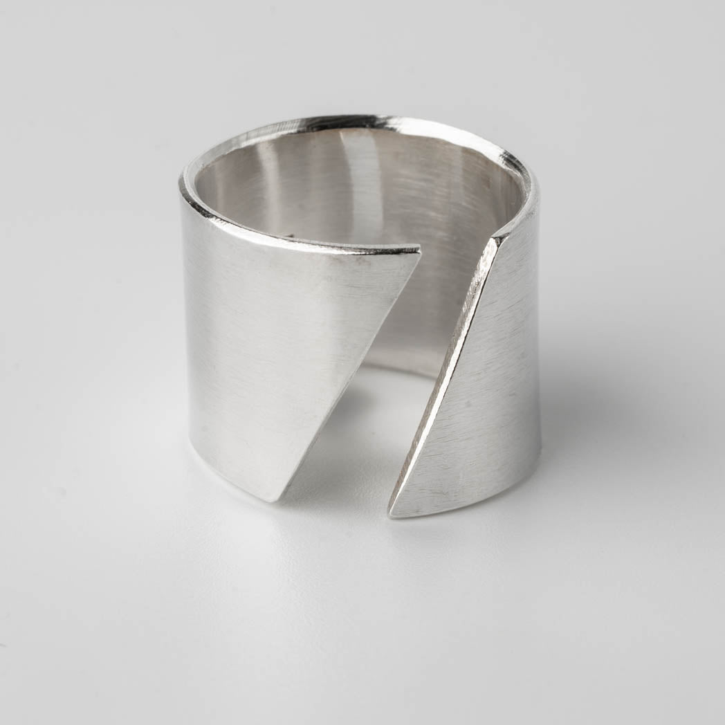 Bred silverring i Àkta silver med diagonal öppen design, handgjord och elegant, fotograferad mot vit bakgrund.