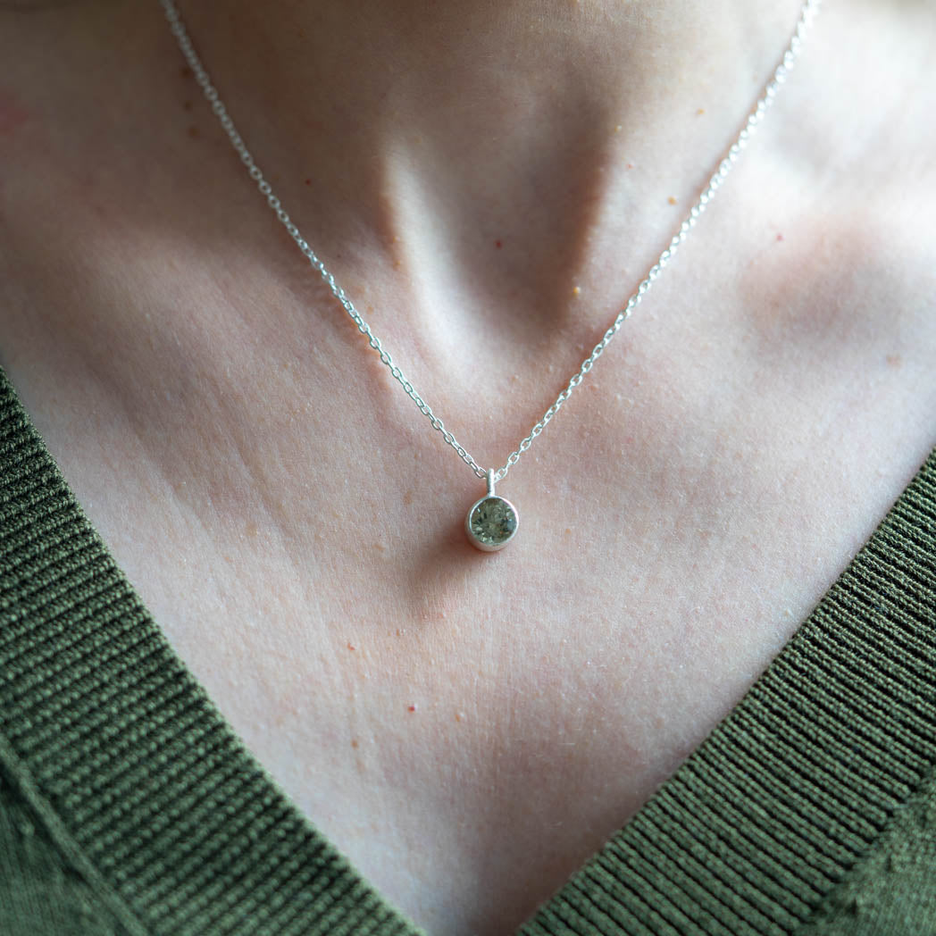 Halsband i silver med en champagnefärgad turmalin – en mjuk och elegant detalj runt en dams hals.