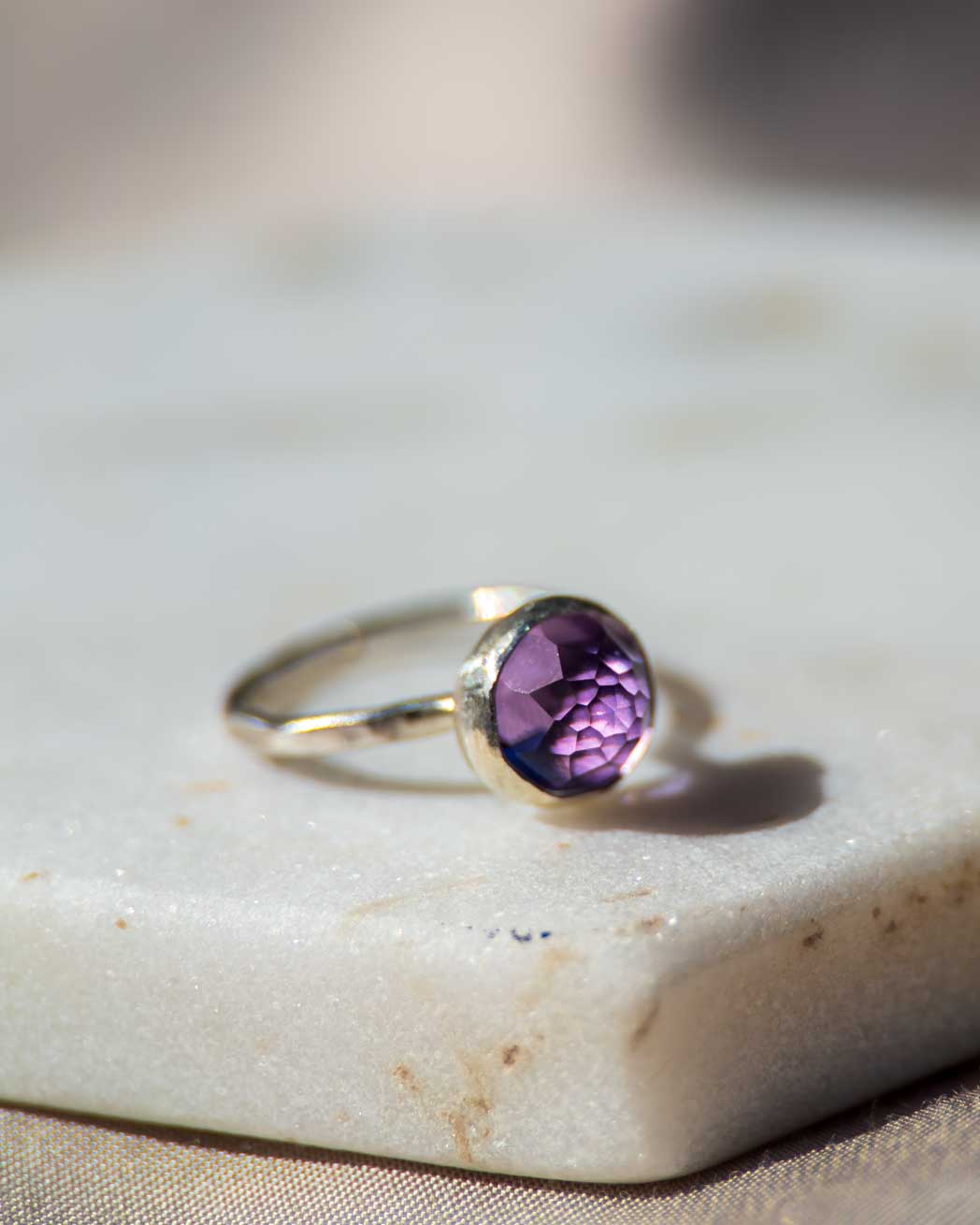 En rund handgjord silverring med en rosenslipad lila ametist.