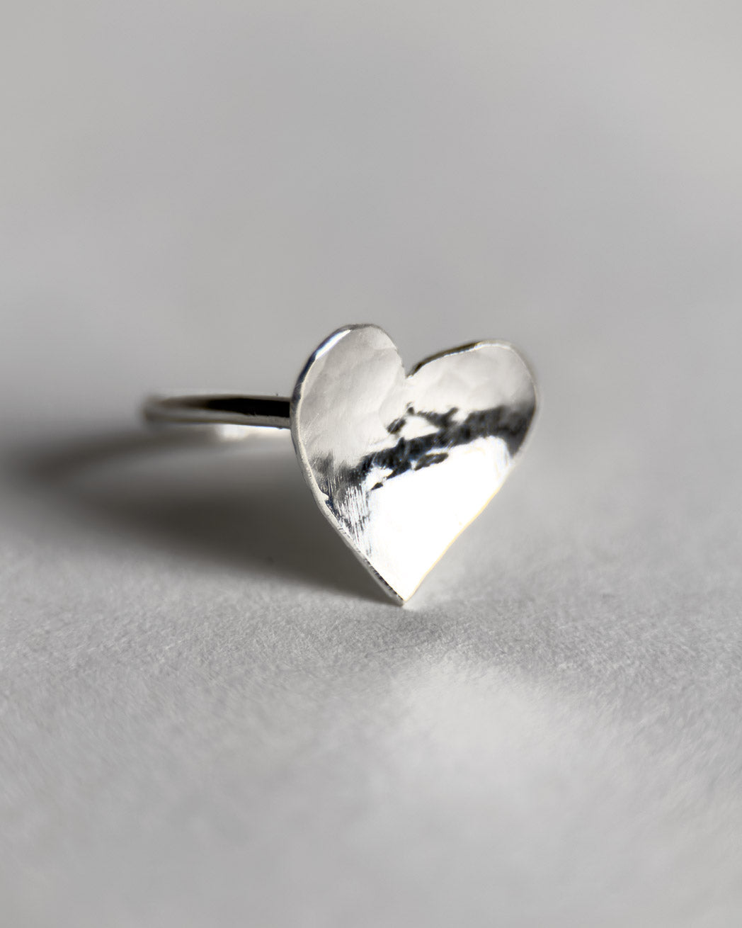 Tunn ring i silver med ett stort hjärta.