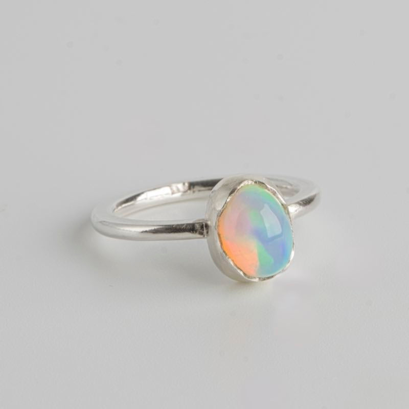 Handgjord opal silverring från Nude Stockholm på vit bakgrund.