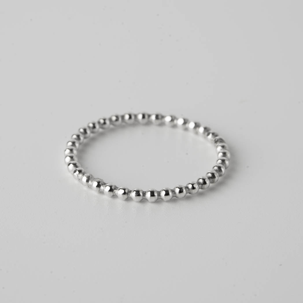 Bubblig – handgjord silverring i 925 sterlingsilver, 1,50 mm tjock, med en lekfull och elegant design, fotograferad mot vit bakgrund.