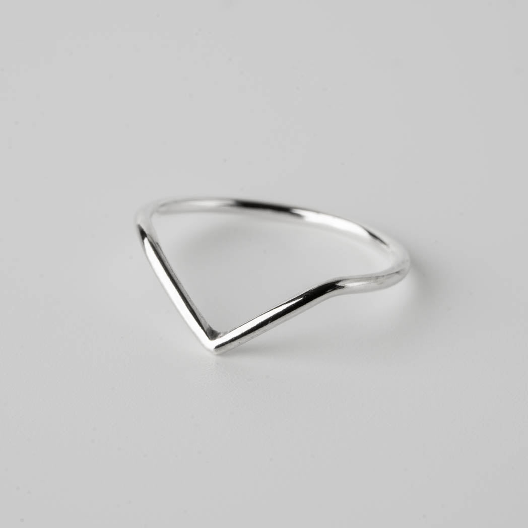 V-formad blank ring â handgjord smal silverring i 925 sterlingsilver med en modern V-formad design, fotograferad mot vit bakgrund.