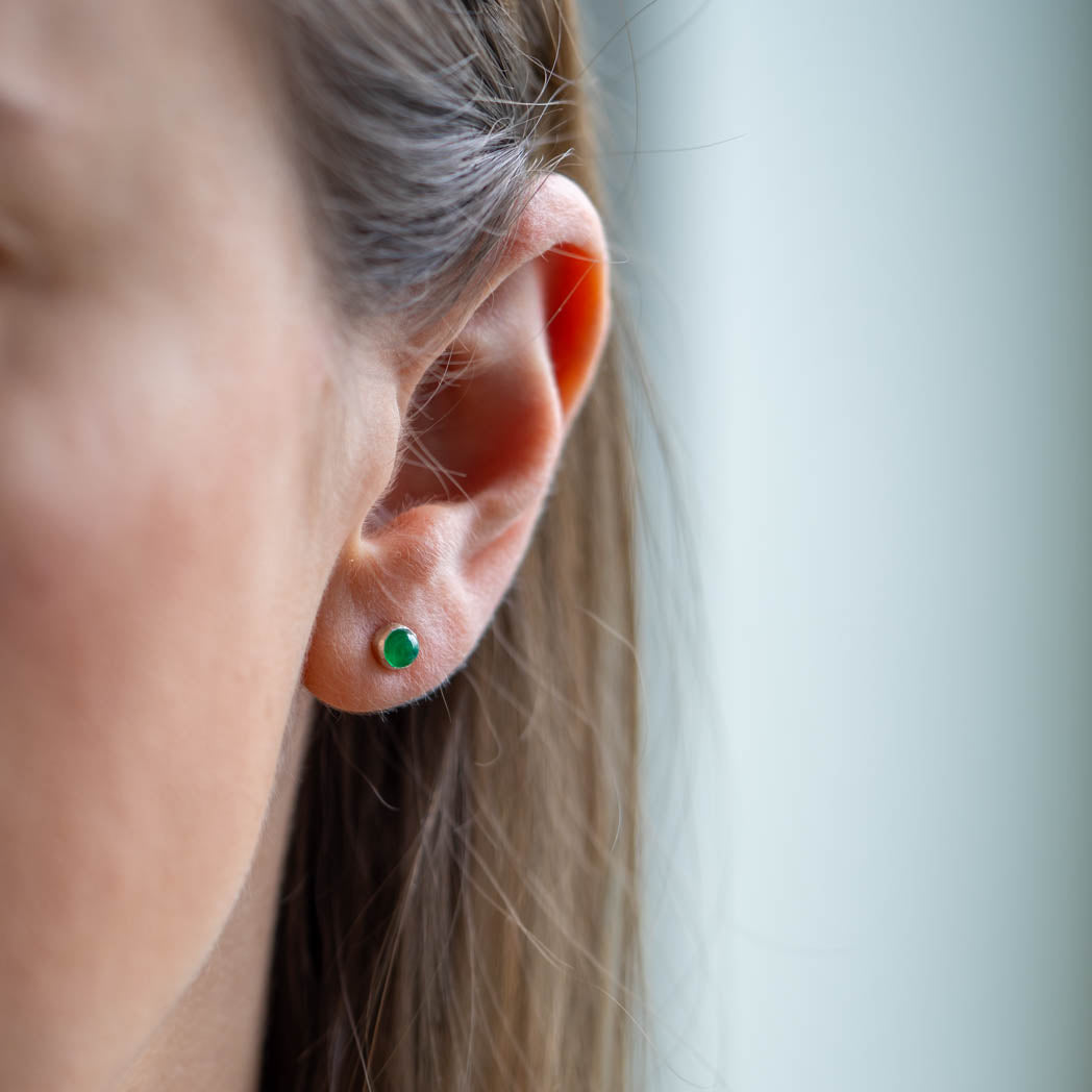 Smaragd studs på en dams öra.
