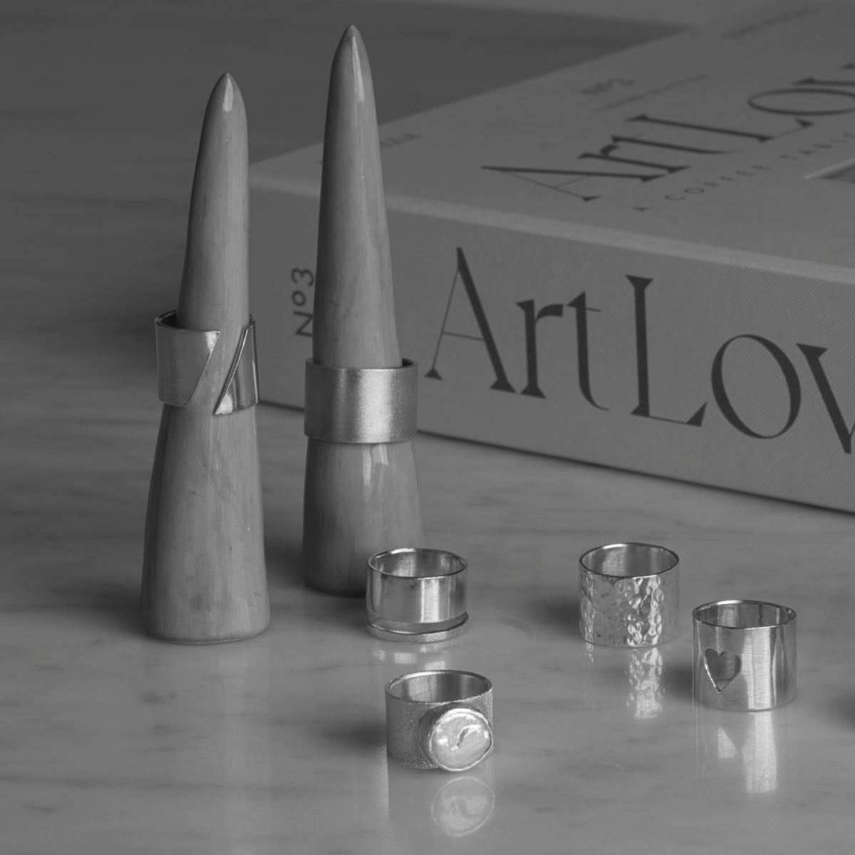 Breda silverringar i 925 silver från kollektionen Bold, visade på marmor med ringstativ