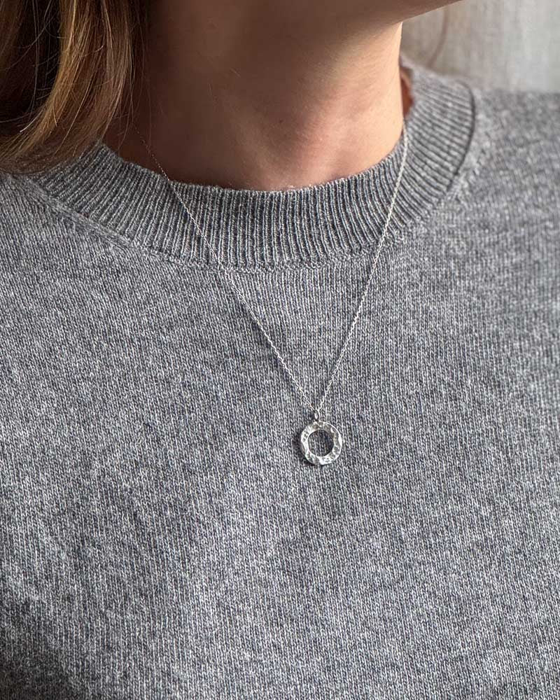 Silverhalsband med ett hängsmycke.