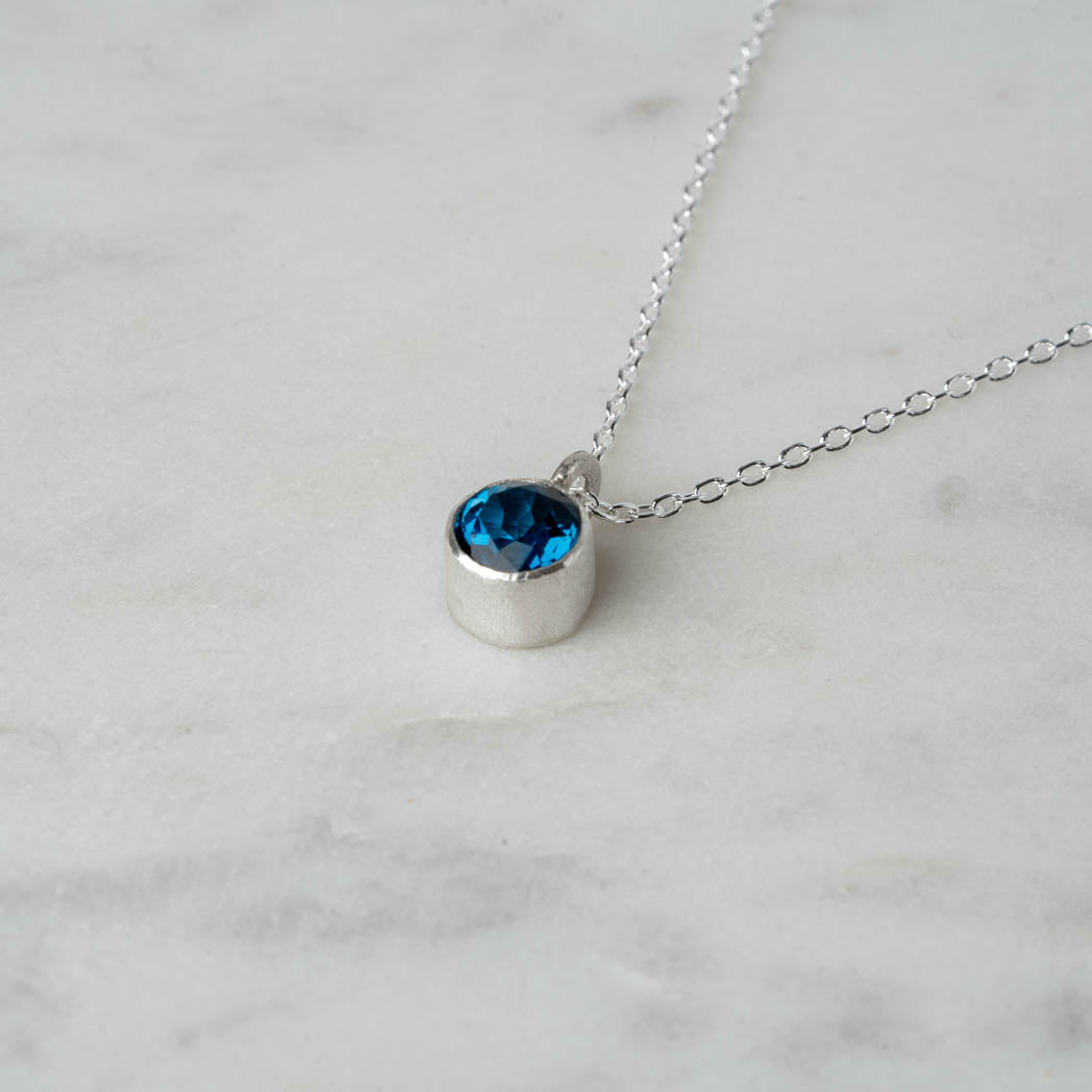 Elegant silverhalsband med rund, facetterad London Blue Topas – tidlös design med vacker lyster.