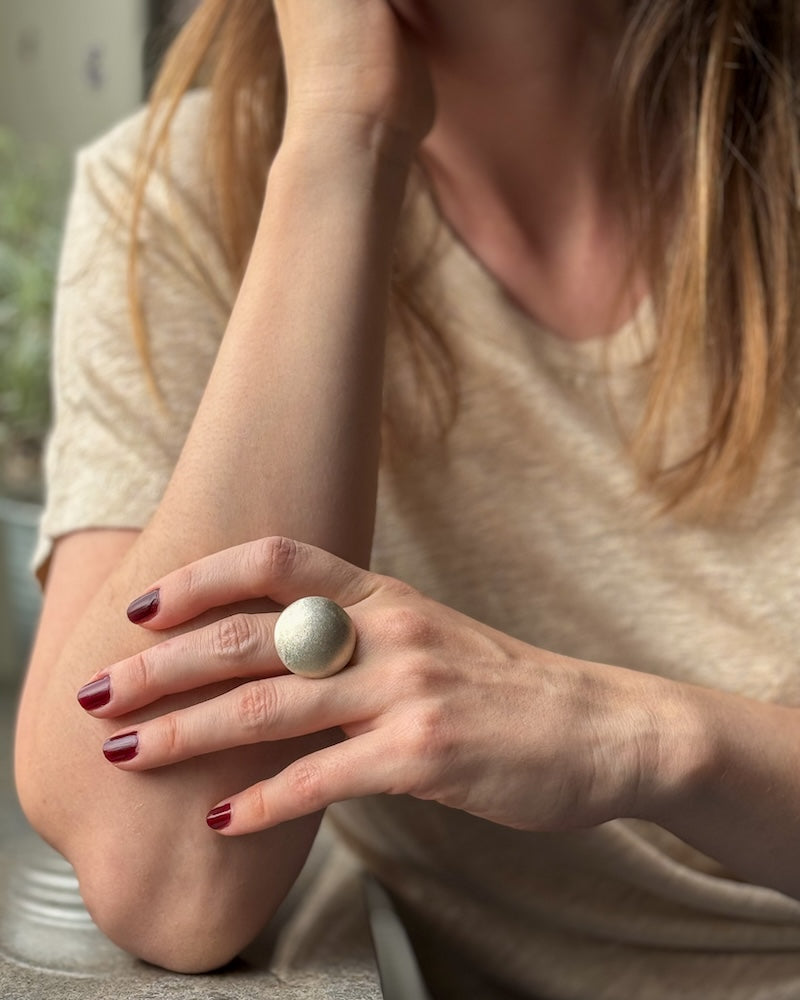 Vår breda silverring måne på en kvinnas hand.